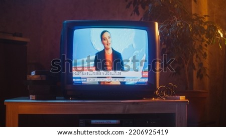 Close Up Footage of a Dated TV Set Screen with Breaking News Report. Beautiful Female Host Reads Important News on Live Television Broadcast. Nostalgic and Retro Nineties Technology Concept.