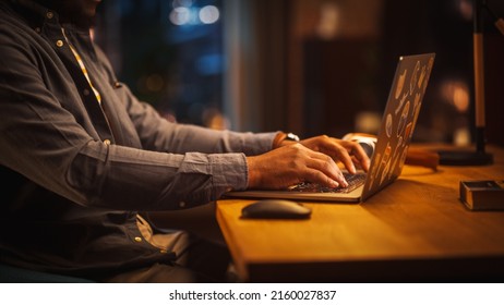 Close Up Footage of Person's Black Hands Use Computer while Sitting at a Table. Creative Designer in a Grey Shirt Using Mouse, Typing on Keyboard. Monitor Display and Laptop on a Desk. - Powered by Shutterstock
