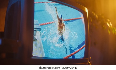 Close Up Footage Of A Retro TV Set Screen With Live Sports Swimming Competition Broadcast. Athletic Male Performing Aerobics In A Pool. Nostalgic Dated Nineties Technology Concept.