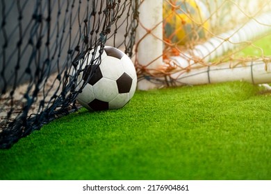 Close Up Of A Football And Goal Lying On The Grass With Little Sun Ray Coming Through. It Reminds Us Of A World Class Festival, Once Every Four Years Like The World Cup.