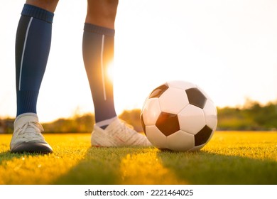 Close Up Football Player Kick And Shoot Ball In Stadium During Training For Champion Competition Sport Activity At Sunset Time