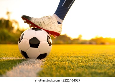 Close Up Football Player Kick And Shoot Ball In Stadium During Training For Champion Competition Sport Activity At Sunset Time