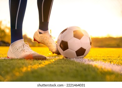 Close Up Football Player Kick And Shoot Ball In Stadium During Training For Champion Competition Sport Activity At Sunset Time