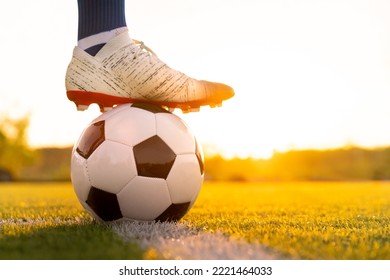 Close Up Football Player Kick And Shoot Ball In Stadium During Training For Champion Competition Sport Activity At Sunset Time