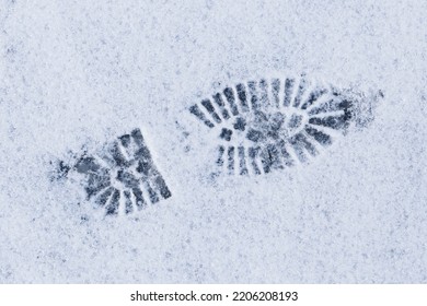 close up of footprint from a boot on snow