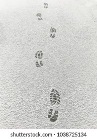 Close up of footprints from hiker boots in snowy winter frost with copy space