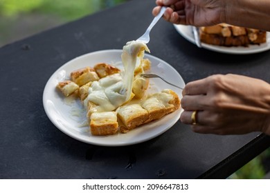 close up fork with toasted bread with butter and condensed milk