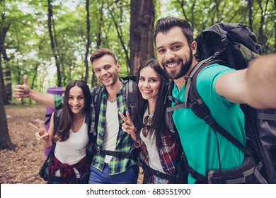 Close up of four cheerful  friends in the spring nice wood, embracing, posing for a selfie shot, that handsome brunet is taking