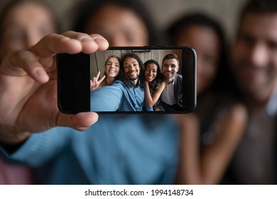 Close up four diverse mixed race best friends posing for selfie, making photo on smartphone, having fun taking memory picture or recording funny video streaming in social network, friendship concept.