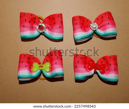close four red and green bows for the top notes of dogs lie on a brown background.  accessories .  bow in the form of a watermelon