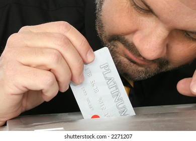 Close Up Of Fourty Something Man Placing Credit Card Into Paper Shredder.