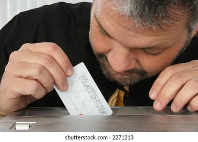 Close Up Of Fourty Something Man Placing Credit Card Into Paper Shredder.