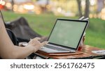 Close up of Freelancer working with laptop at table outdoors on sunny day