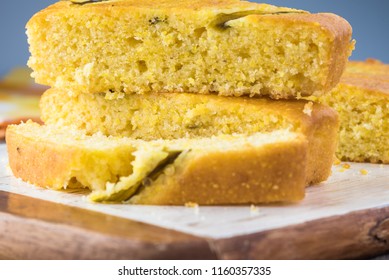 Close Up Of Fresh Baked Cut Hatch Chili Pepper Cornbread On A Cutting Board.