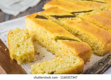 Close Up Of Fresh Baked Cut Hatch Chili Pepper Cornbread On A Cutting Board.