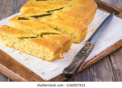 Close Up Of Fresh Baked Cut Hatch Chili Pepper Cornbread On A Cutting Board.