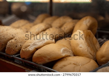 Close up of fresh bread rolls in bakery display.