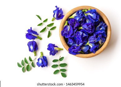 Close up fresh butterfly pea flower or blue pea, bluebellvine ,cordofan pea, clitoria ternatea with green leaf in wooden bowl isolated on white background. Top view. Flat lay.