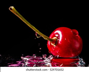 Close Up Of Fresh Cherry Berrie With Water Drops And Splash On Black Background