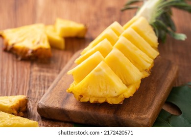 Close up of fresh cut pineapple on a tray over dark wooden table background. - Powered by Shutterstock