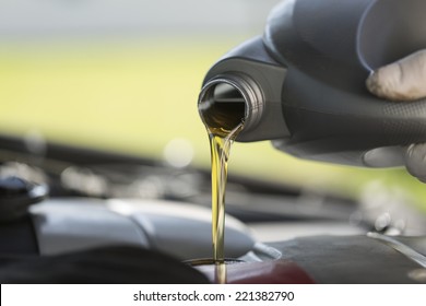 Close up of fresh oil being poured into a car during it's required service. 