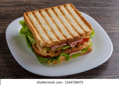 Close Up Of Fresh Sandwich With Ham, Bacon,tomatoes On White Plate