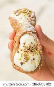 Close Up Of A Fresh Sicilian Cannoli, Held By Hand, Sicily, Italy