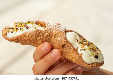 Close Up Of A Fresh Sicilian Cannoli, Held By Hand, Sicily, Italy