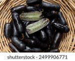 close up a  fresh Sweet black seedless Moon Drops grape,Purple Witch Finger grapes,Sapphire Grapes or Witch Fingers grape isolated on 
in a wooden basket.black grapes. Grapes black taste sweet 