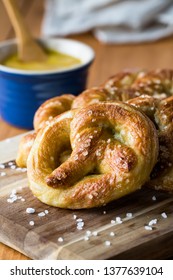 Close Up Of Freshly Made Baked Pretzels With Course Salt And A Side Of Honey Mustard Dip Ready For Eating.