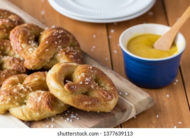 Close Up Of Freshly Made Baked Pretzels With Course Salt And A Side Of Honey Mustard Dip Ready For Eating.