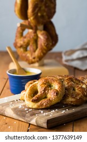 Close Up Of Freshly Made Baked Pretzels With Course Salt And A Side Of Honey Mustard Dip Ready For Eating.