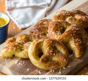 Close Up Of Freshly Made Baked Pretzels With Course Salt And A Side Of Honey Mustard Dip Ready For Eating.