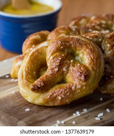 Close Up Of Freshly Made Baked Pretzels With Course Salt And A Side Of Honey Mustard Dip Ready For Eating.