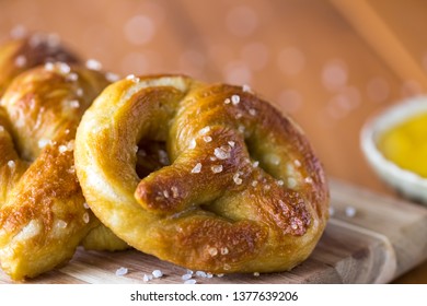 Close Up Of Freshly Made Baked Pretzels With Course Salt And A Side Of Honey Mustard Dip Ready For Eating.