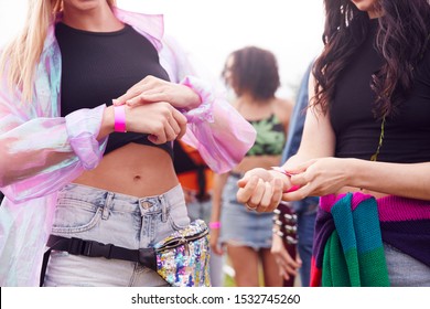 Close Up Of Friends At Entrance To Music Festival Putting On Security Wristbands