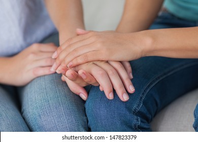 Close friends touching hands at home on the couch - Shutterstock ID 147823379