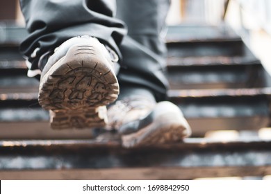 Close Up Of The Front Of A Boot As A Person Is Walking Down Some Stairs, A Person In Hiking Boots