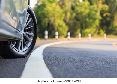 Close up front car wheel on the asphalt road