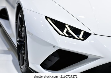 Close Up Front Headlights Of White Super Car On Black Background, Copy Space	