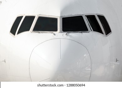 Close Front Outside View Of A White Big Jet Plane Cockpit.