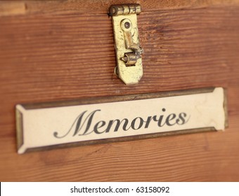 Close Up Of The Front Of A Plain, Wooden Box Featuring A Tarnished Latch And Label Holder Containing The Word, 