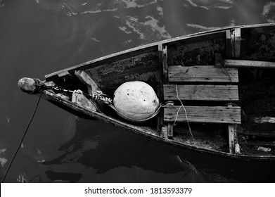 Close Up Of Front Side Of Small Fisherman Wooden Boat Moored In Port. Small Row Boat Floating , View From Top Angle Black And White Photography