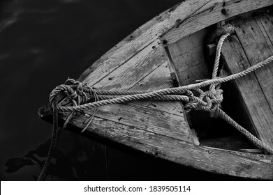 Close up of front side of small fisherman boat moored in port. small row boat floating , view from top angle black and white photography