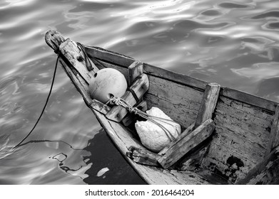 Close Up Of Front Side Of Small Fisherman Wooden Boat Moored In Port. Small Row Boat Floating , View From Top Angle Black And White Photography