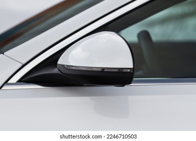Close up front view of car side mirror. Front rear view mirror on the car window. White car exterior details.