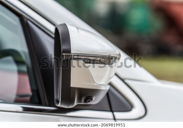 Close up front view of car\
side mirror. Front rear view mirror on the car window. Car exterior\
details.