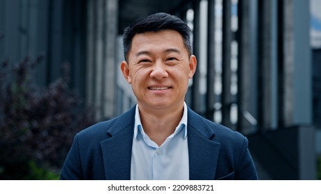 Close up front view in city outdoors Asian Korean man business boss leader company CEO smiling glad happy middle-aged businessman professional financial advisor executive leader manager male lawyer - Powered by Shutterstock