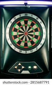 Close up front view of a digital electronic dartboard mounted in an arcade setting. Ideal for sports recreation features, game night promotions, and target competition concepts.