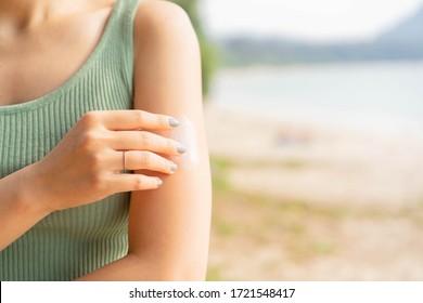 Close Up Front View Of Woman Applying Sunscreen Lotion To Skin At Beach In Holiday For Protect About Sunlight , Healthy Lifestyle And Summer Season Concept